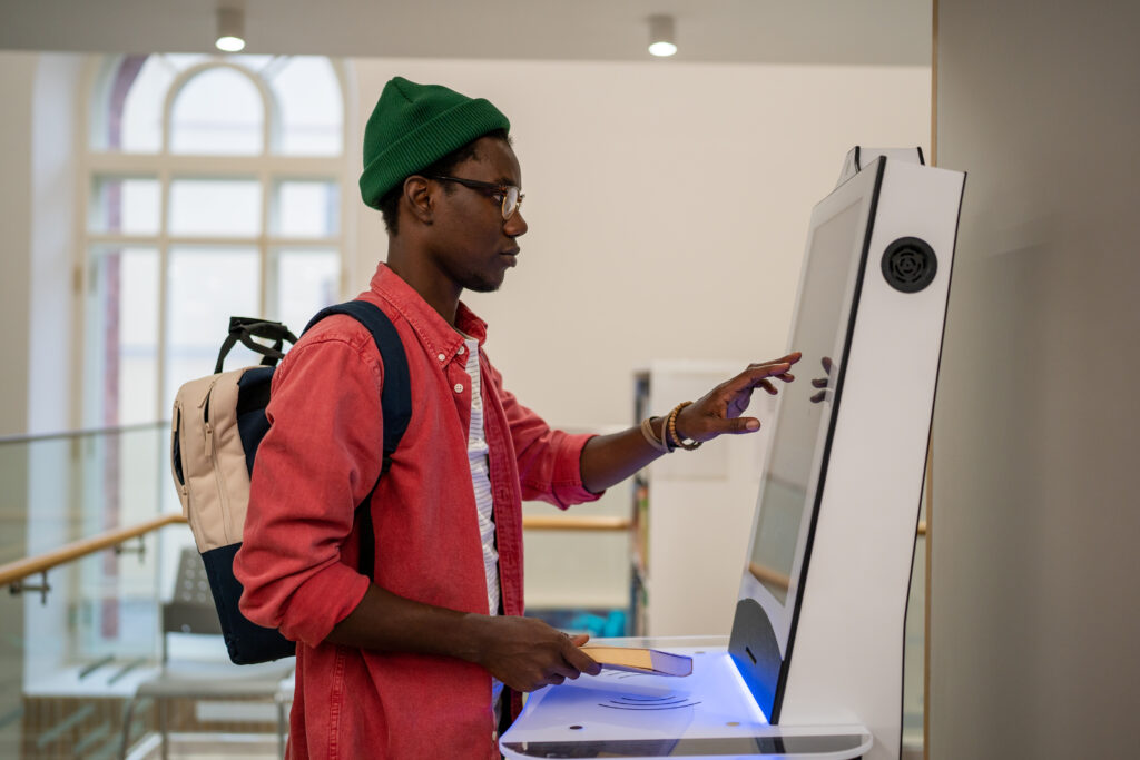 Customer using an interactive in-store kiosk to engage with a touchscreen in a retail environment.