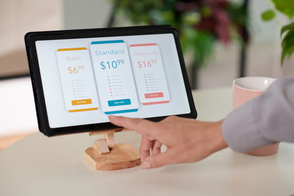 Customer selecting a pricing option on an interactive in-store kiosk with touch screen.