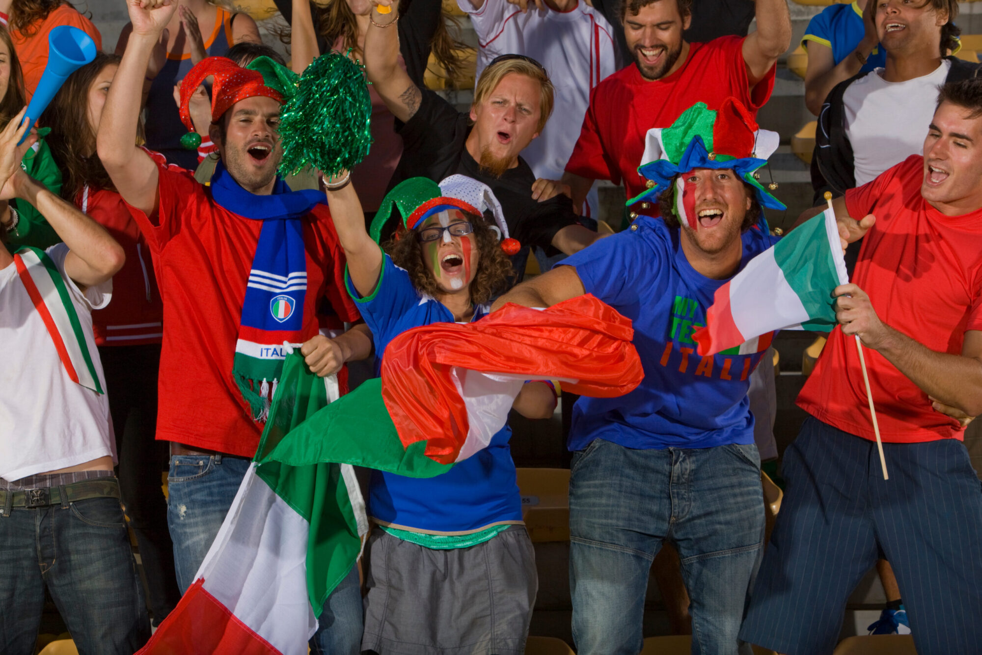 Italian soccer fans cheering with flags and face paint at a FIFA World Cup-style stadium watch party